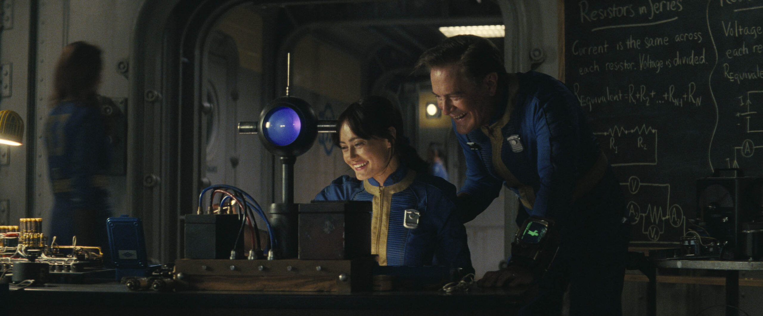 Ella Purnell (Lucy) e Kyle MacLachlan (Overseer Hank) in Fallout 1x01 [credit: Copyright Amazon Content Services LLC; courtesy of Prime Video]